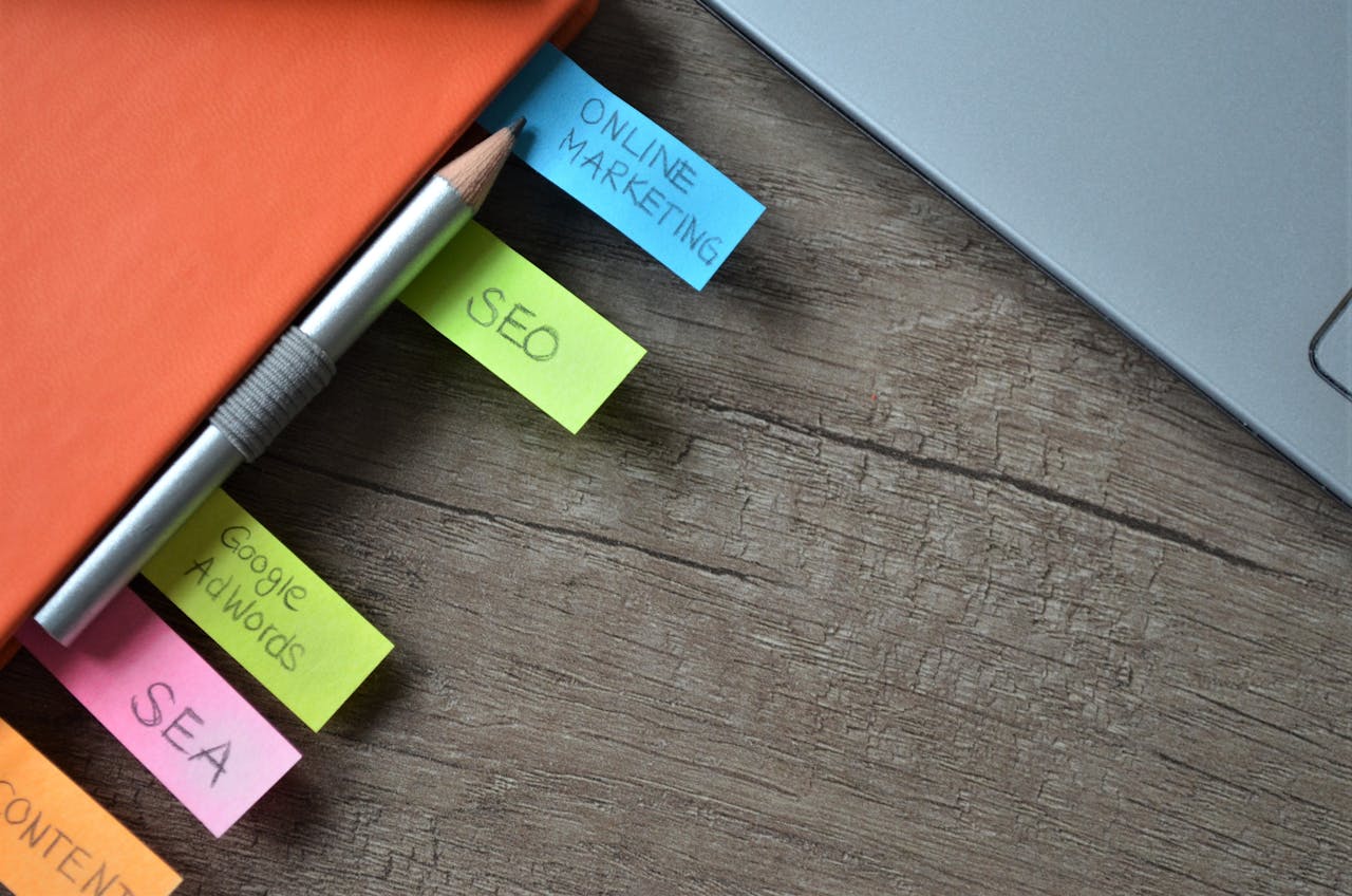 about-us-01 Close-up of SEO strategy planner with colorful sticky notes and a pencil on a notebook.